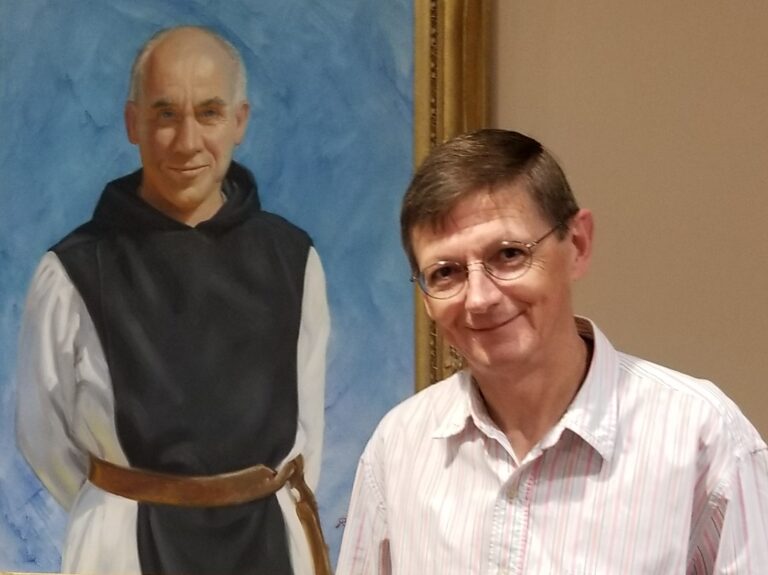 Paul in front of a portrait of Thomas Merton